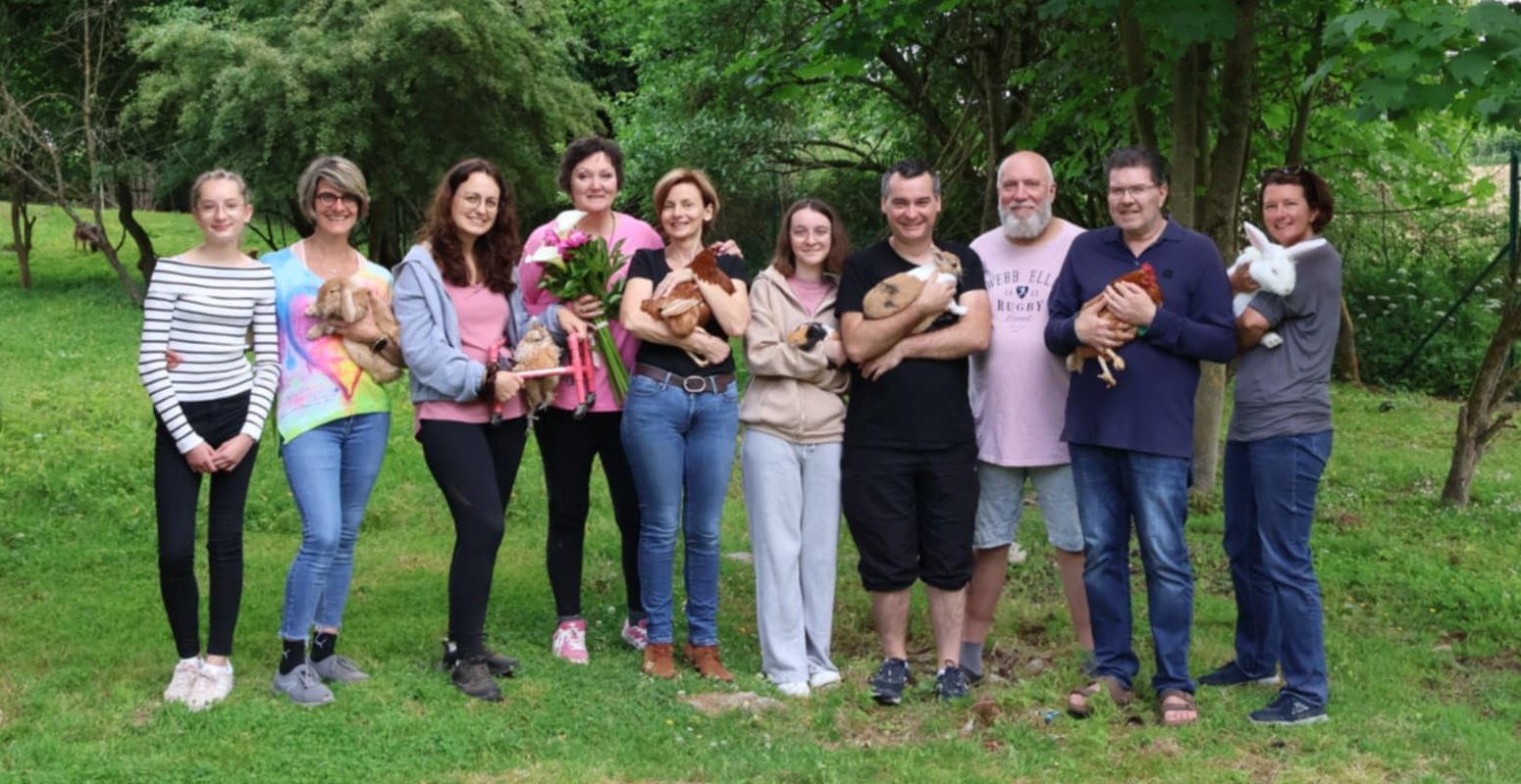 L'équipe des bénévoles réunie au refuge, chacun avec un animal dans les bras